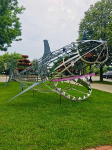 Art Walk Central Installation 2019, featuring a large, metal shark, roughly 15 feet long at Town Center in Downtown Mt. Pleasant, Michigan.