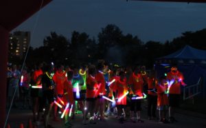 Glow in the Park participants running with glow sticks, glow outfits during this annual 5k race in the dark in Mt. Pleasant, Michigan.
