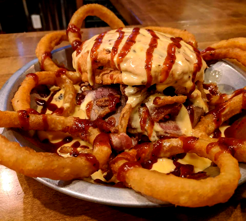 The Smokin’ J: Smoked brisket piled high with bacon and fried onion straws on an onion bun, slathered with Summit’s smoky cheese sauce. WARNING! You’ll need a fork, knife and bib for this monster of a sandwich from Summit Smokehouse & Tap Room in Mt. Pleasant, Michigan.
