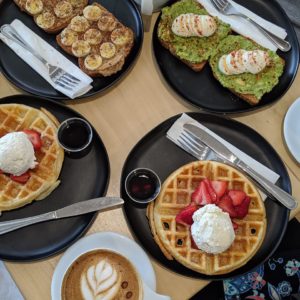 Ponder Coffee Company breakfast menu items, including strawberry waffles, avocado toast, Ponder roasted coffee and banana peanut butter toast in Mt. Pleasant, Michigan.