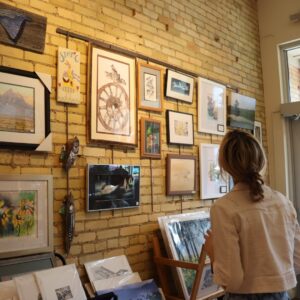 A patron observing different artwork for sale at the Art Reach Consignment shop.