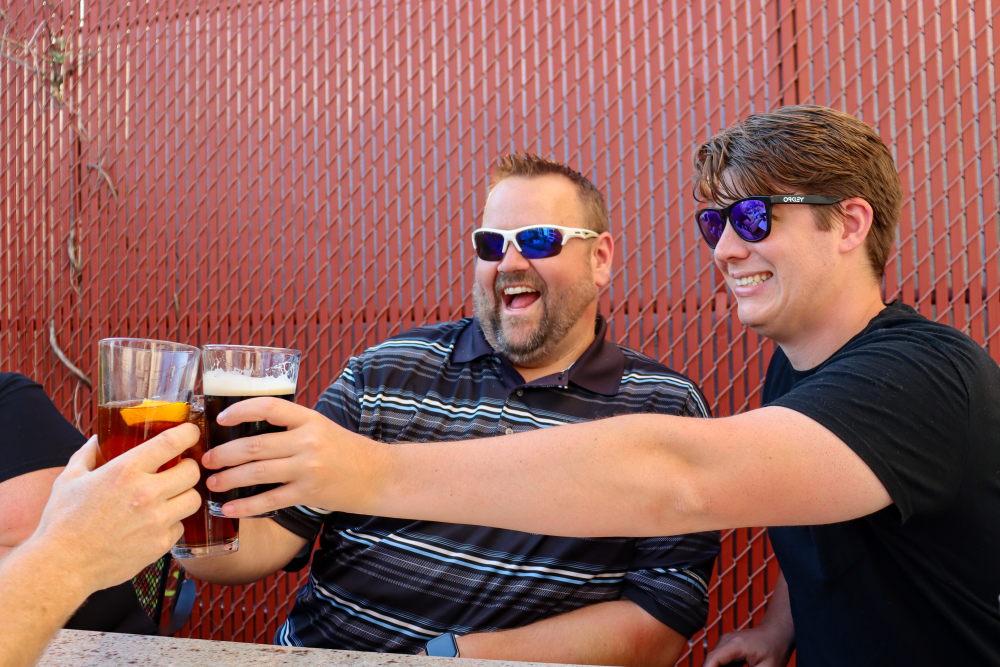 Patrons raising their glasses to cheers on the Hunters Ale House patio.