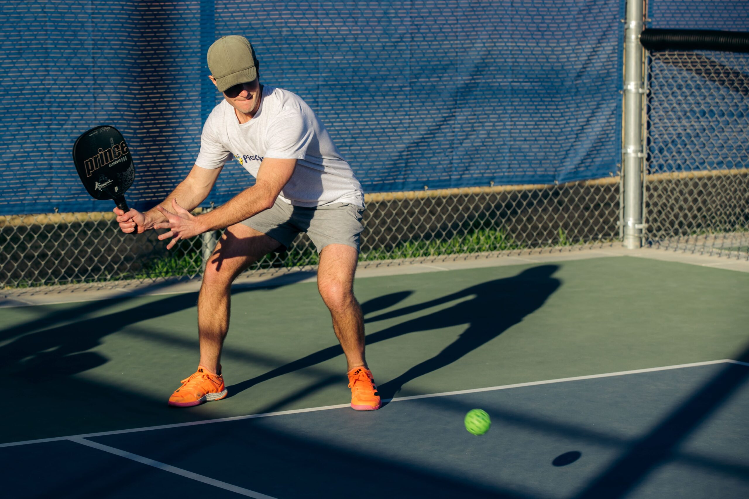 A man getting ready to hit a Pickleball ball.